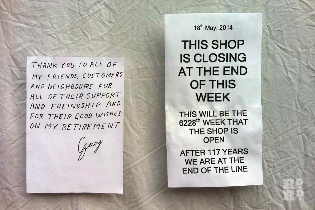 Notices in shop window announcing closure of Arbers stationery shop on Roman Road in 2014.