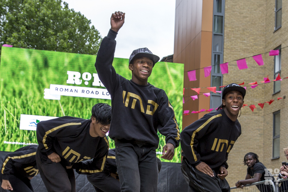 IMD Legion dancers performing in front of Roman Road outdoor screen