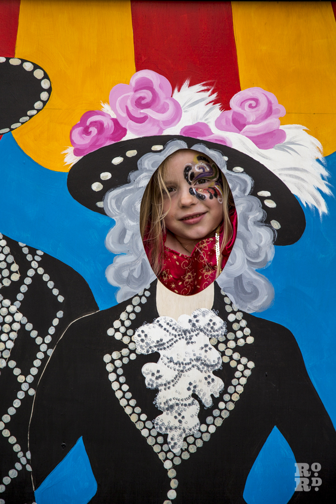 Young girl with face painted, Aunt Sally board East End style of Pearly Queen and Pearly King