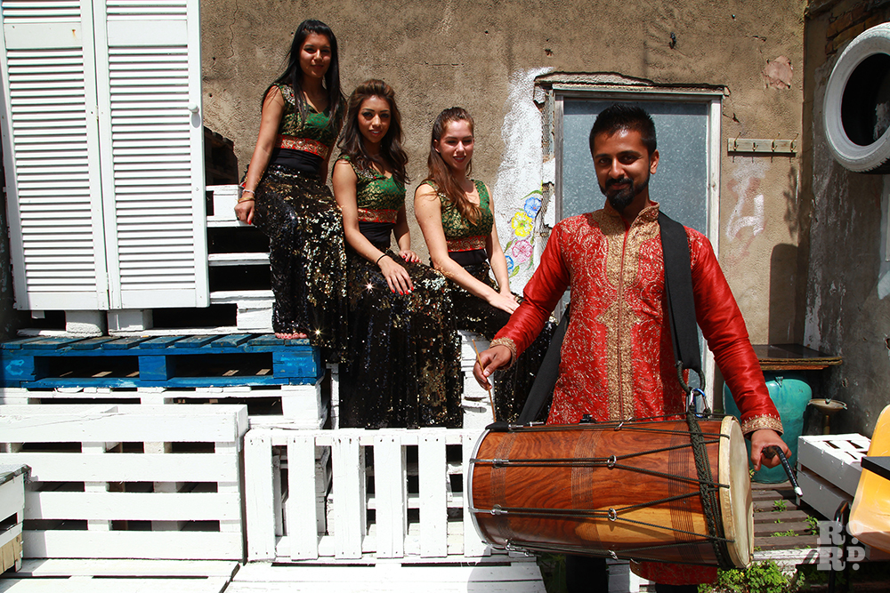 Bollywood dancers and drummer in courtyard