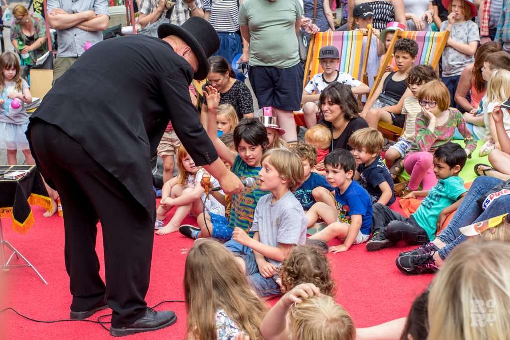 Magician entertaining children at Roman Road Summer Festival 2016