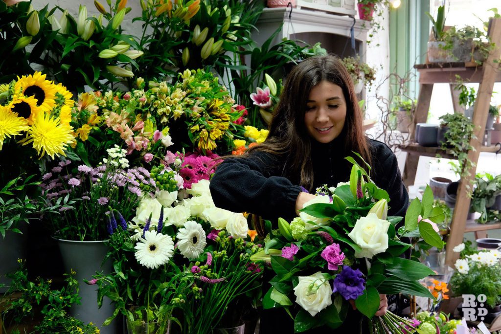 Florist arranging flowers in Denningtons on Roman Road, East London