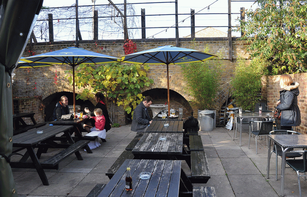 People sat at benches in the beer garden of the Lord Tredegar in Bow, East London