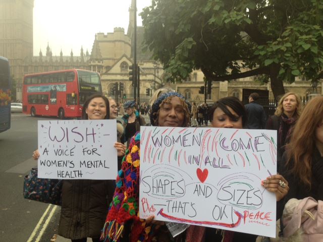 Women stand outside the Houses of Parliament demonstrating