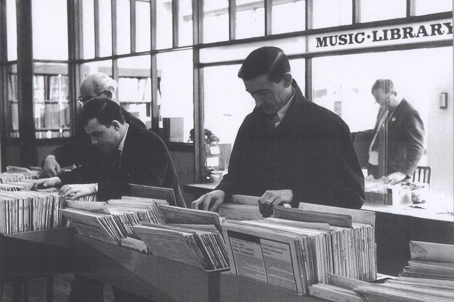 Men browsing vinyls in music library