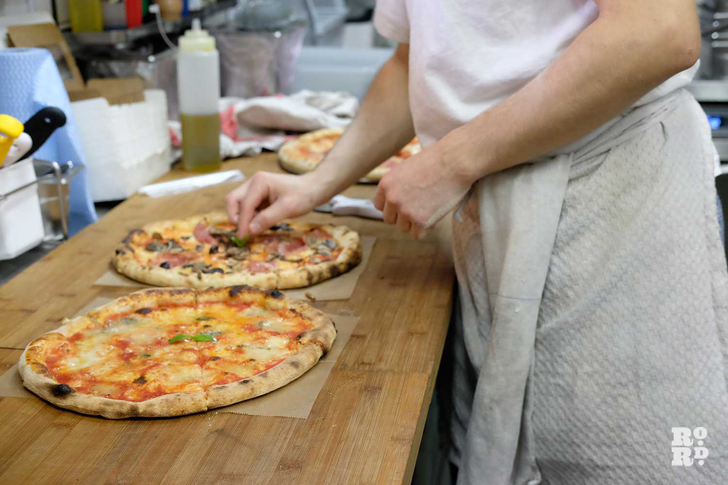 Pizza being prepared in a kitchen in Pizza Room in Mile End
