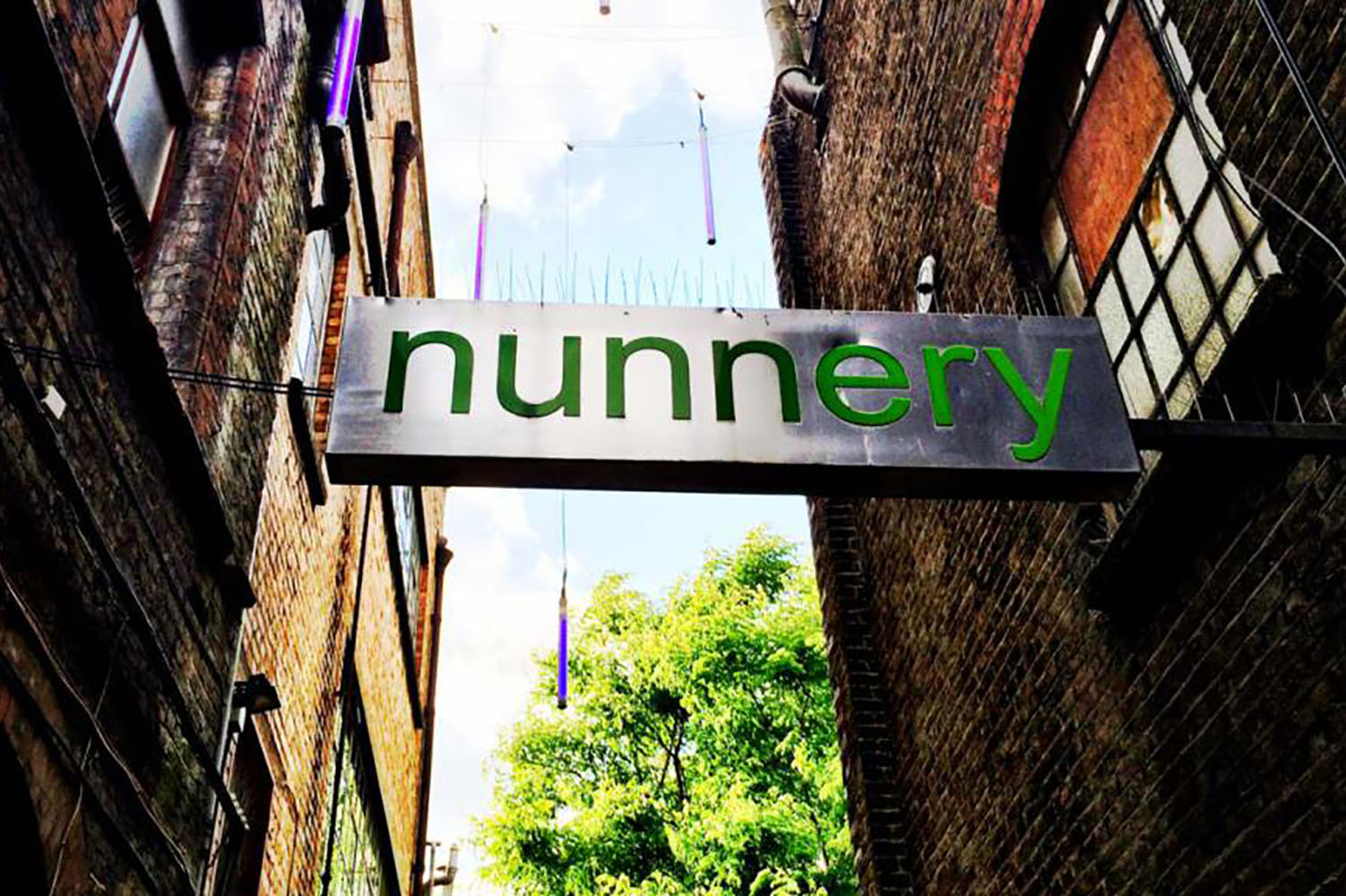 Sign for the Nunnery gallery hanging across Victorian alleyway in Bow East London