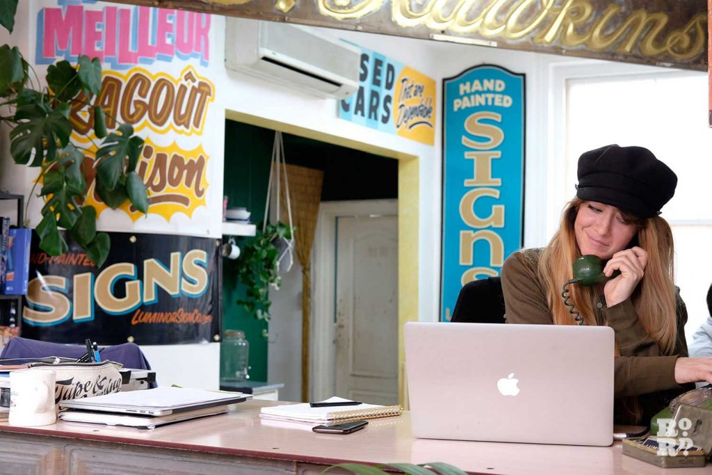Studio manager Louise Anscomb takes a call at Luminor Sign Co