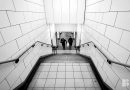 couple walking up tiled stairs of mile end tube station