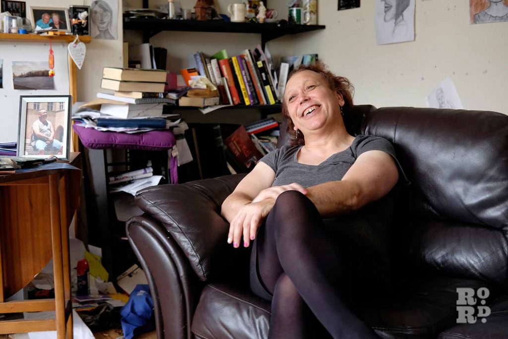 Daniella, local trans woman, laughing on her sofa