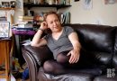 Daniella, trans woman living in Tower Hamlets, sitting on her sofa