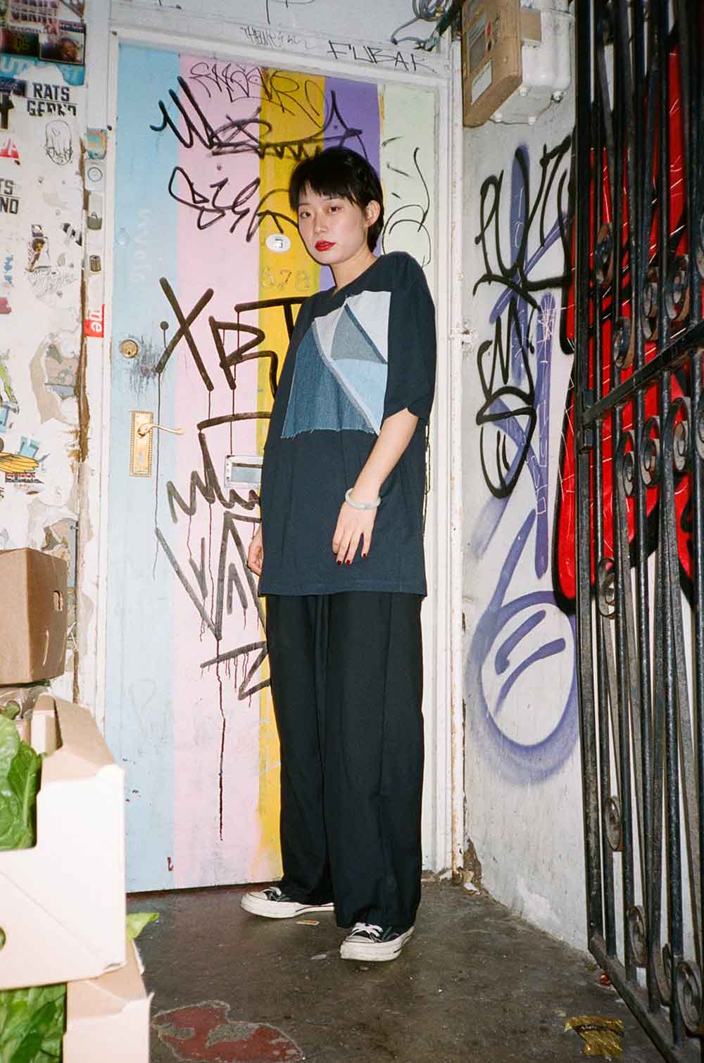 model wearing blue shirt against graffiti wall Atika fashion shoot Roman Road