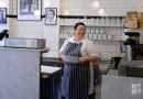 G.Kelly pie and mash Roman Road staff member holding stack of dishes