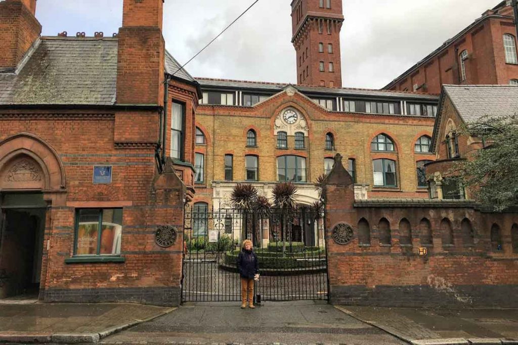 Sam Johnson standing outside the gates of Bow Quarter, former Bryant and May match factory