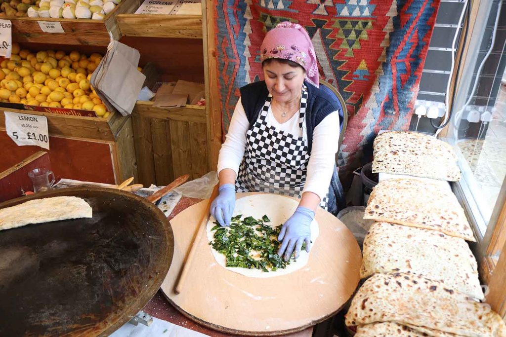 Turkish woman making gozleme pancakes at Akdeniz store on Roman Road, East London