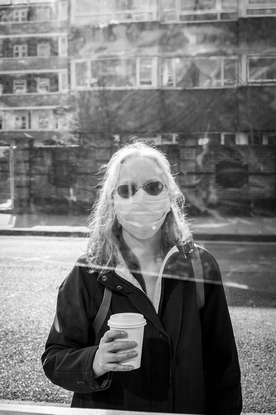 Black & white portrait of coffee shop customer through a window