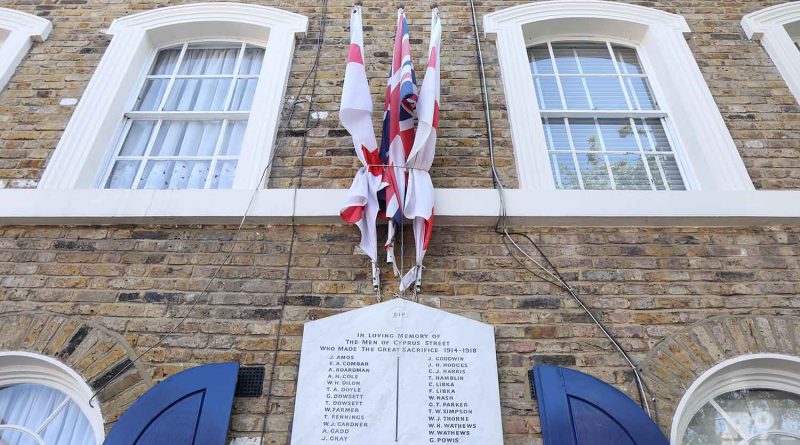 English and British flags over war memorial on Cyprus Street in Bethnal Green, East London.