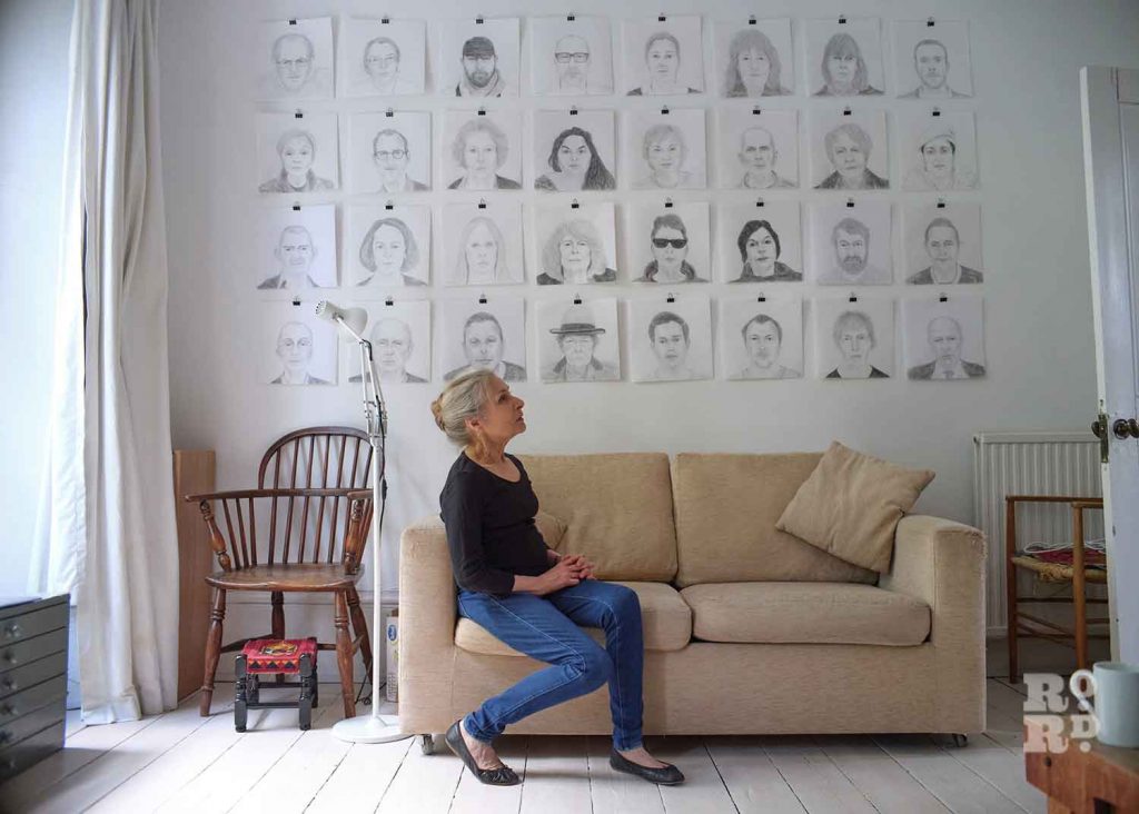 Alice Sielle and her wall of sketch portraits.