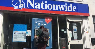 A man withdraws cash from the atm outside the Nationwide bank on Roman Road.