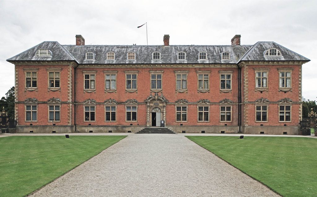 Tredegar House face on with driveway and green grass on either side of the photo