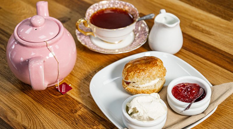 Scones, cream and jam with a pink teapot and a cup of tea, The Bakery Room, Roman Road, East London