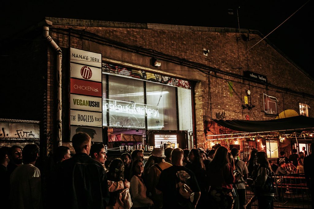 A large group of people outside the club, Colour Factory, at night in Hackney Wick, East London