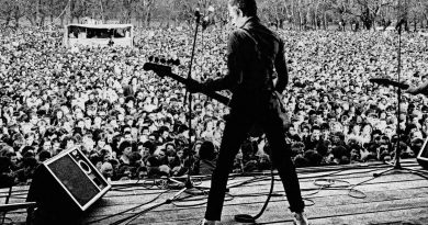 Paul Simonon playing in front of a crowd at 'Carnival Against the Nazis' concert, Victoria Park, East London