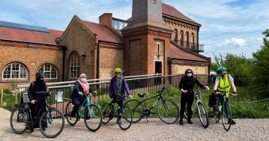 Cycle Sisters in front of old red brick factory