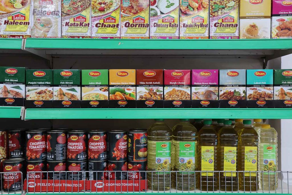 Neat shelves of food products at Subhan the butchers on Roman Road Market.