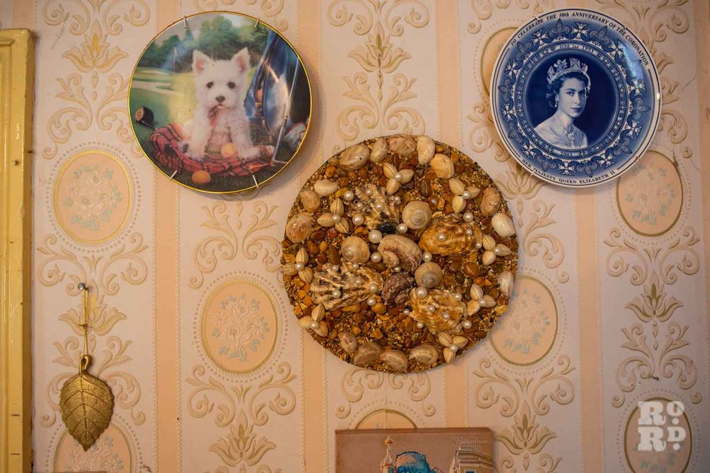 A large blue plate of the queen mounted on a wall in a house on Lichfield Road, Bow, East London