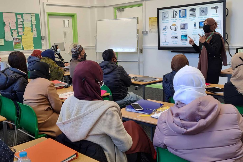 a woman leading a workshop in a classroom in Bromley-by-Bow centre, Bow, East London