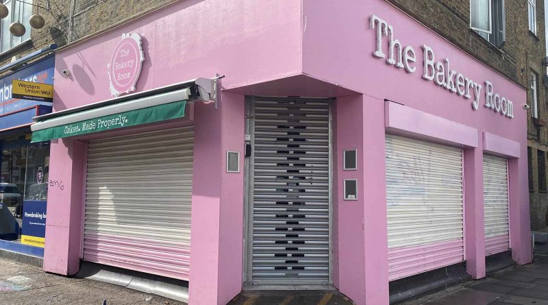 shutters down on pink corner cafe on Roman Road market, Bow, East London