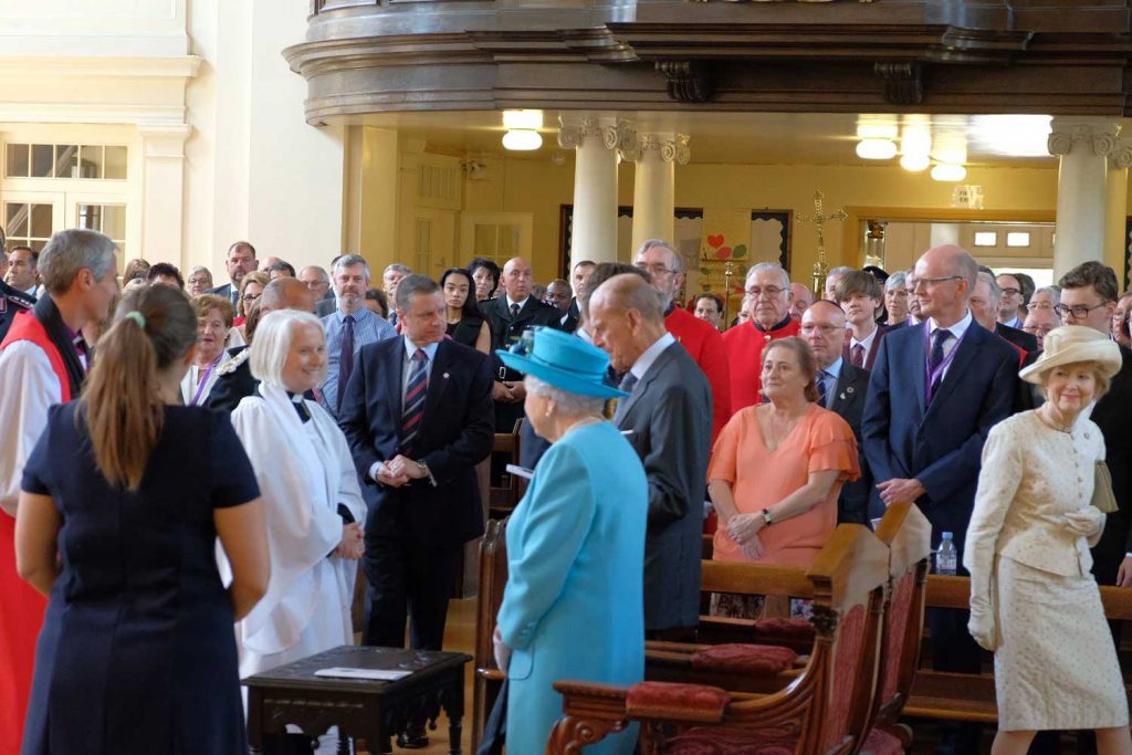 Queen Elizabeth and Prince Philip standing in All Saints Church in Poplar for a service, Tower Hamlets, East London