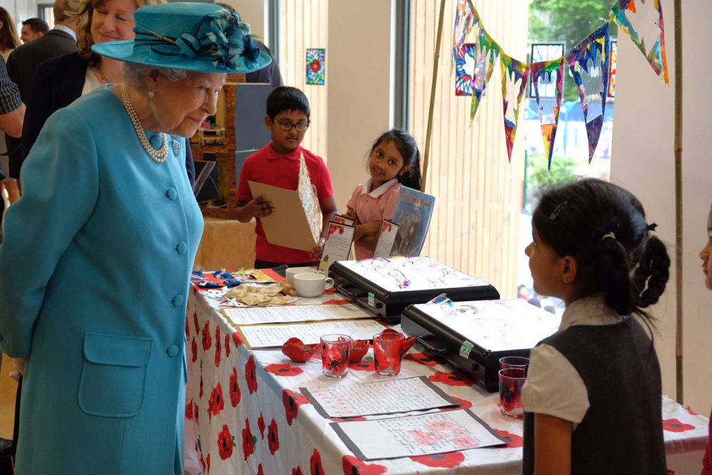Queen Elizabeth inside a school talking to a school pupil in Tower Hamlets, East London