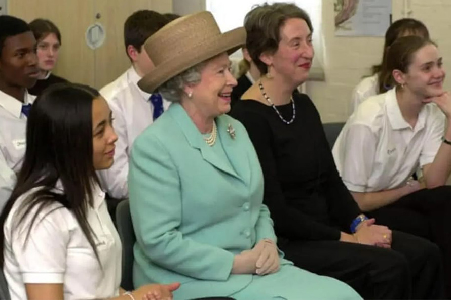 Queen Elizabeth sits between a teacher and pupils while on a school visit to Morpeth School, Bethnal Green, East London