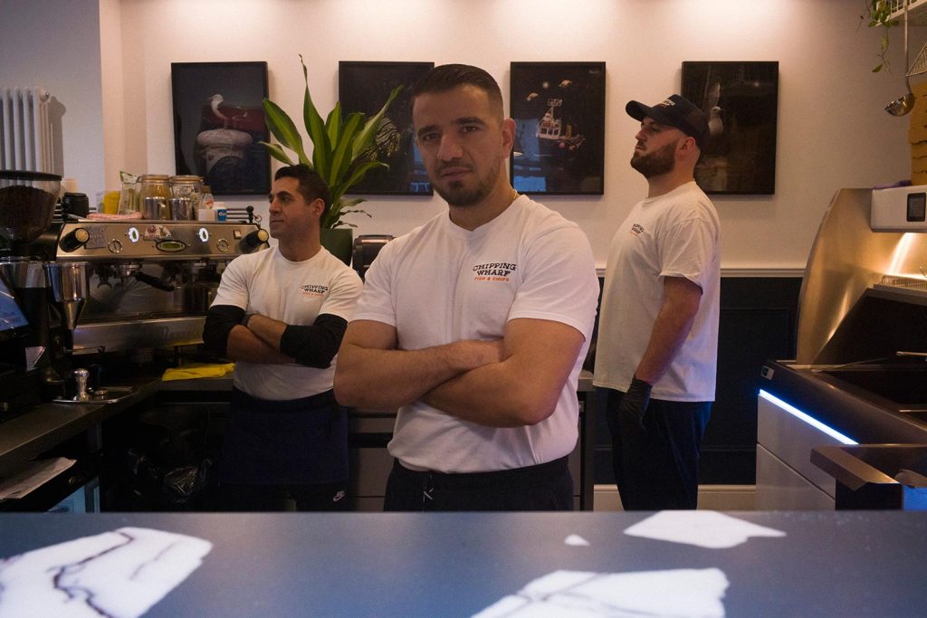 Mustafa Has with his team at the new fish and chip shop on Old Ford Road, Chipping Wharf.