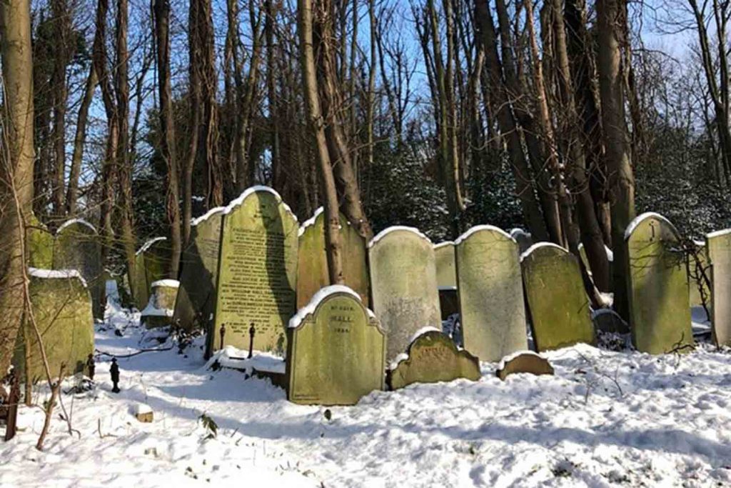 Graves in the snow at Tower Hamlets Cemetery Park. 