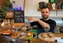 Alex Navarro serving vegan sausage rolls behind the counter at Jungle Electric cafe.