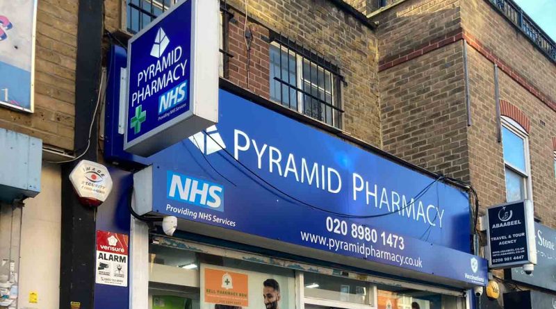 outside Pyramid Pharmacy with sign out side with NHS logo.
