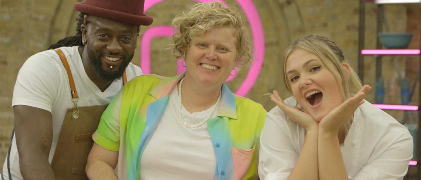 Terri with two colleagues from masterchef on either side. The pink masterchef logo is in the background.