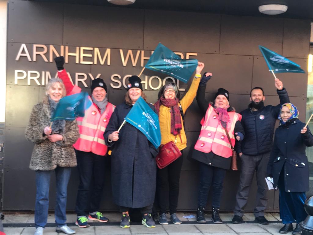 Teachers from Arnhem Wharf Primary School waving flags on the picket line outside of school.