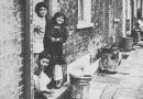 Bengali children standing outside of a house in the East End.