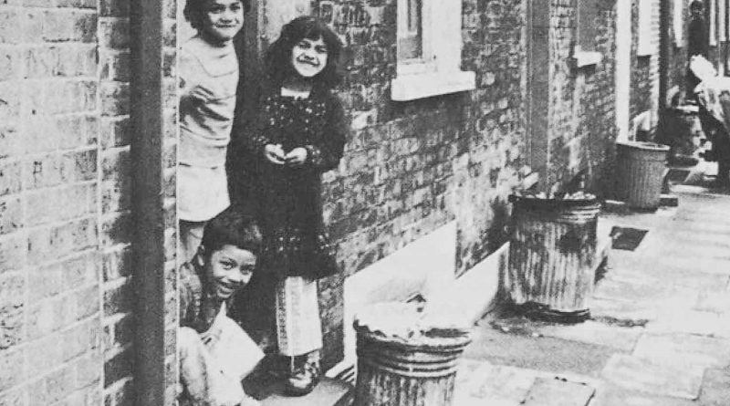Bengali children standing outside of a house in the East End.