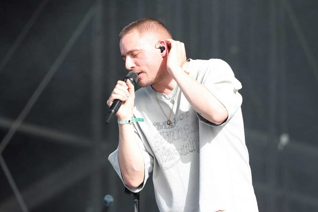 Dermot Kennedy Irish singer-songwriter performin on stage with a mic in his hand.