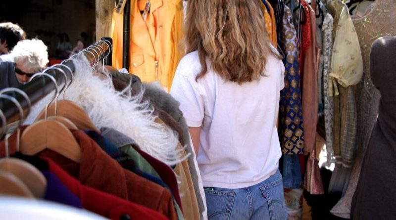 Woman browsing through clothing racks at Flea London
