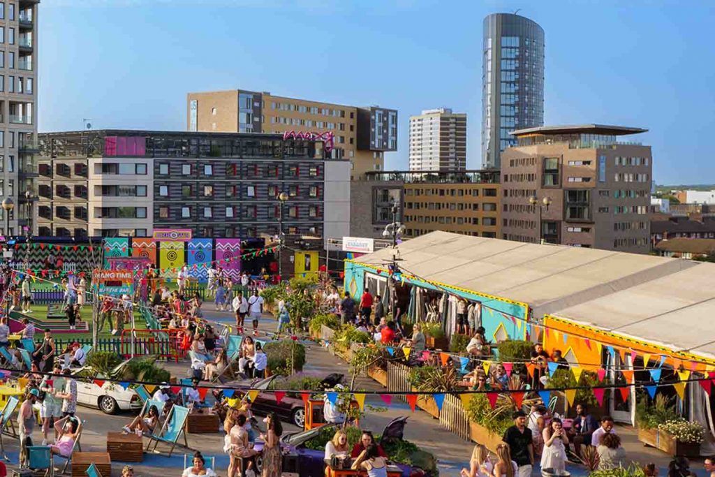 A large and busy rooftop with stalls for restaurants, bars, and actvities such as crazy golf.