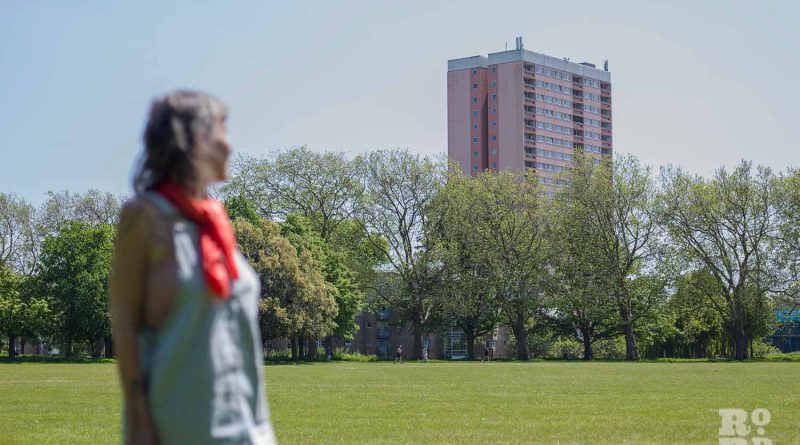 Former resident Nada Holland standing in Victoria Park, looking back at Clare House, Bow, East London.