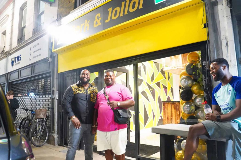 Big Narstie Grime MC and the owner of Jerk and Jollof, Chuks, standing outside the restaurant on Roman Road at its opening evening.