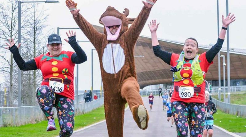 Three dressed-up Christmas runners in Queen Elizabeth Olympic park.