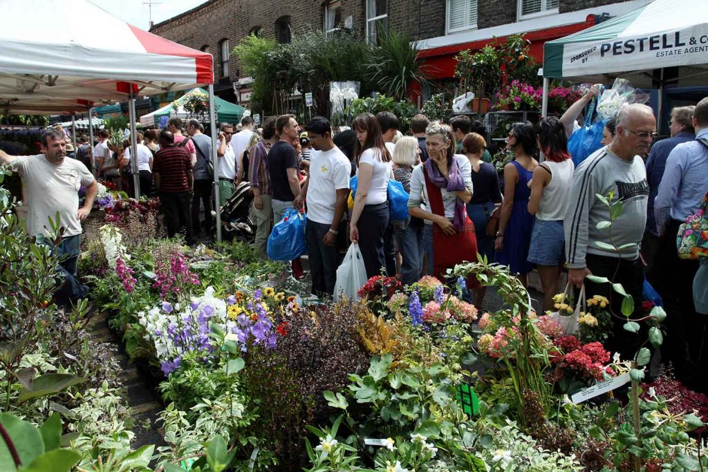 A bustling Columbia Road Flower Market with several colourful plants and customers